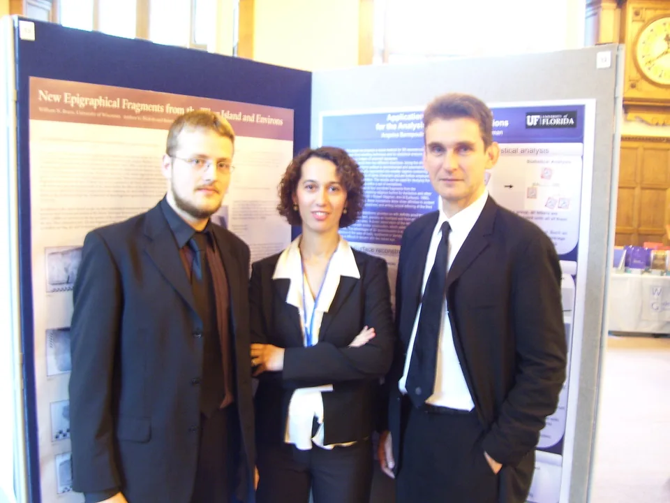 Three project members standing together in front of a conference poster.