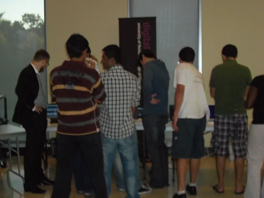 A group of visitors gathered around demonstration tables at the exhibit.