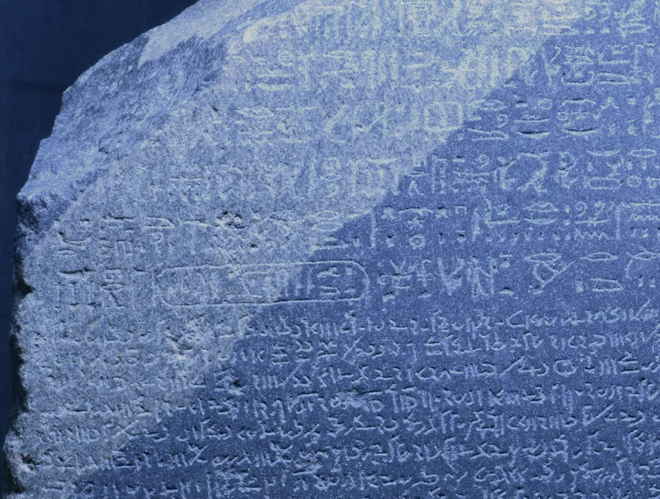 Blue-tinted photograph of a region of the Rosetta Stone showing hieroglyphic signs.