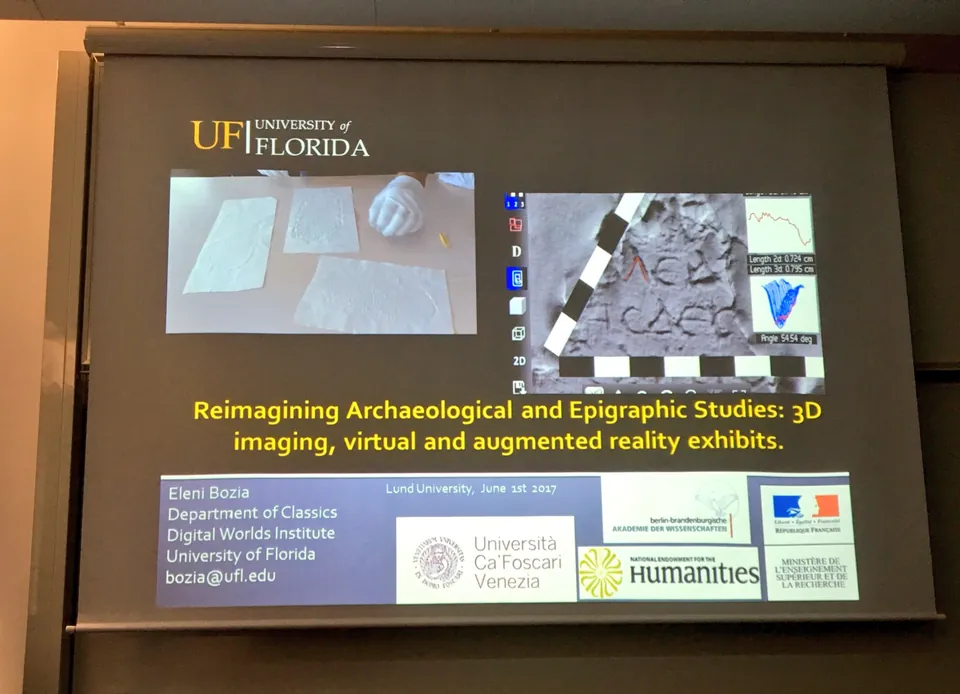 Projected slide titled “Reimagining Archaeological and Epigraphic Studies: 3D imaging, virtual and augmented reality exhibits”.