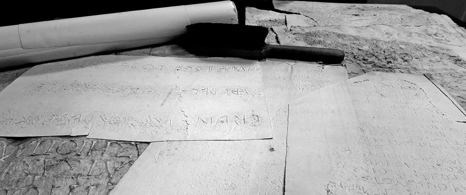 Grayscale 3D rendering of paper squeezes with inscription impressions.